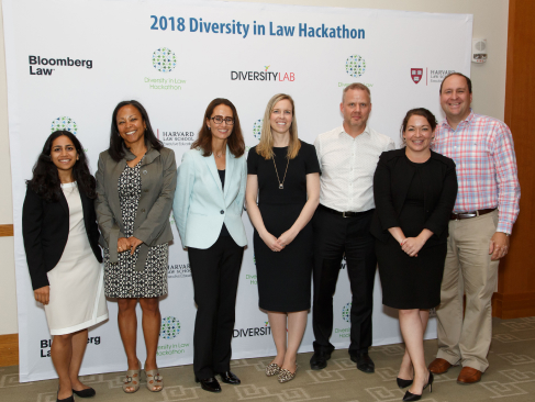 A group of people stand in front of a backdrop that says 2018 Diversity in Law Hackathon