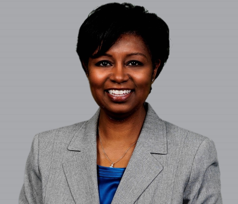 Headshot of Tonya Robinson, a woman with short hair against gray background smiling at the camera