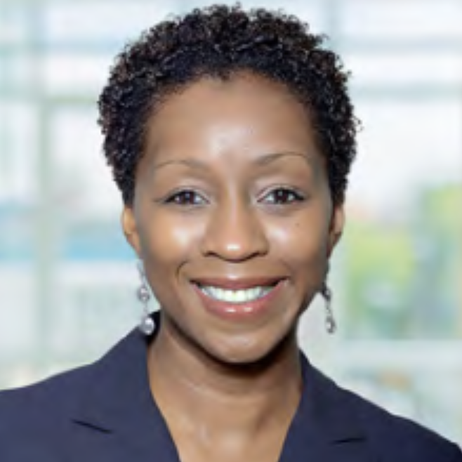 Headshot of Lia Dorsey, a woman with dangling earrings and gray blazer smiling at the camera